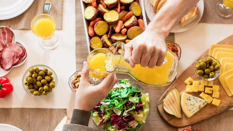 Table spread with a variety of finger foods and orange juice