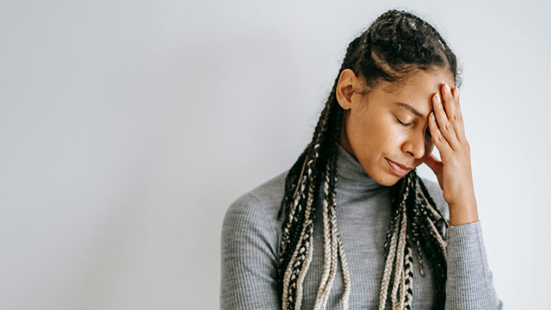 Stressed woman with hand on forehead