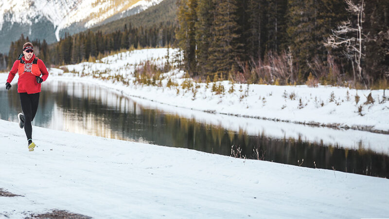 Man running near lake during winter